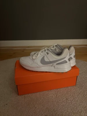 Nike Air vita golf  sneakers med grå swoosh - Nike Air sneakers i vitt med grå swoosh och detaljer. Lågt skaft, snörning och meshpaneler för extra andningsförmåga. Klassisk sportig look med bekväm sula och diskret branding på hälen. Perfekta för dig som gillar stilrena och tidlösa sneakers. Jag köpte dom för 1099kr men dom kostar igentligen 1499kr men dom passade tyvär inte mig jag använde dom en runda golf.
