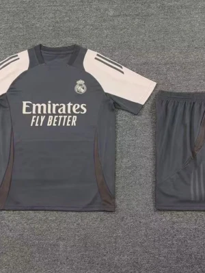 Real Madrid träningsset grå - Säljer ett grått träningsset från Real Madrid med kortärmad tröja och matchande shorts. Tröjan har vita och svarta detaljer, klubbmärke på bröstet och texten 'Emirates Fly Better' framtill. Perfekt för fotbollsträning eller gymmet.