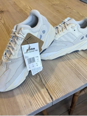 Adidas Yeezy Boost 700 Analog - Säljer ett par Adidas Yeezy Boost 700 sneakers i beige och offwhite. Skorna har en chunky sula, mesh och mockadetaljer samt klassisk Yeezy-design. Perfekta för dig som gillar streetwear och vill ha något som sticker ut. Taggar och originalkartong medföljer.