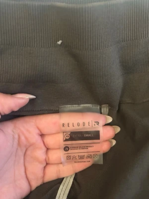 Mörkbruna leggings från Relode - Säljer ett par mörkbruna leggings från Relode i storlek XS. De har hög midja och är tillverkade i ett stretchigt och mjukt material som sitter tight och bekvämt. Perfekta för träning eller chill dagar. Snygg och enkel design utan synliga loggor på benen.