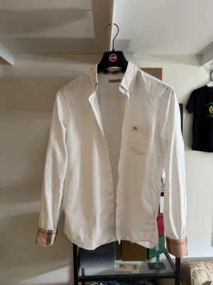 Burberry skjorta vit - Burberry skjorta, äkta i storlek M. Den snyggaste skjortan enligt mig men har tyvär växt ur den. Nypris ca 5500kr. Storlek M men passar även S och L
