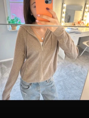 Beige ziphoodie soft goat - Mysig beige soft goat ziphoodie med huva och långa ärmar. Perfekt till jeans och enkel att matcha med olika stilar. Små defekter se bilderna. Men inget som alls syns när den används 