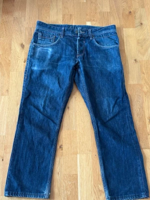 Mörkblå raka jeans - Säljer ett par klassiska mörkblå jeans med rak passform och fem fickor. Jeansen har normal midja, bälteshällor och kontrastsömmar. Materialet är slitstark denim i bomull. Perfekta till en avslappnad stil.