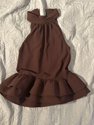 Brun halterneck  topp med volang - Snygg brun halterneck topp och volang nertill. Storlek s från Gina tricot!! Aldrig använt så jätte bra skick!! 