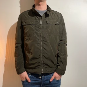 Massimo Dutti Field Jacket  - Säljer denna Field Jacket från Massimo Dutti, perfekt nu för hösten, i grymt skick. Jackan har snygga bruna läderdetaljer och fickor på brösten. Jag är 184. 