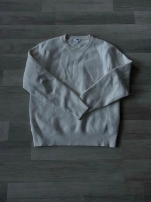 Krämvit Sweatshirt från Uniqlo - Säljer denna riktigt feta sweatshirten i krämvit färg från Uniqlo, knappt använd och nyskick i storleken Small, hör av dig vid minsta fundering