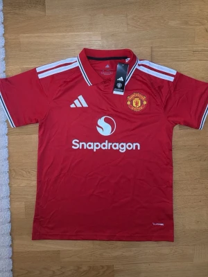 Manchester United matchtröja röd - Säljer en helt ny röd Manchester United tröja, jätte skön material, bra för dig och ha för Manchester uniteds kommande matcher.