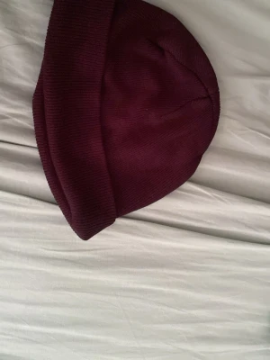 Svart ribbstickad mössa - En enkel och stilren svart mössa med uppvikt kant. Mössan är ribbstickad och har en klassisk passform som funkar till de flesta outfits. Perfekt för att hålla värmen under kyliga dagar.