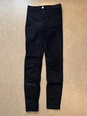 Svarta Gina Tricot skinny-jeans - Svarta skinny-jeans från Gina Tricot i ett skimrande material.