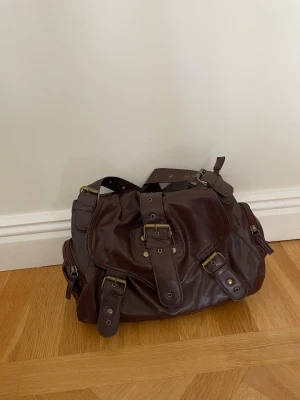 Mörkbrun läderhandväska  - Denna väska ger riktigt 2000s vibes och jag älskar den!!! Skitsnygg och unik modell😍