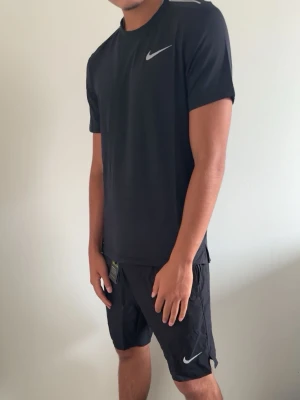 Nike träningsset t-shirt och shorts - Säljer två olika träningsset från Nike, ett i helsvart och ett i ljusgrått. Båda seten består av en t-shirt och shorts med Nike-logga på bröstet och benet. Perfekta för gymmet eller löprundan, tillverkade i lätt och snabbtorkande material.
