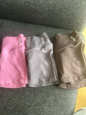 Sömlösa träningshorts från DFYNE - ALLA 3 FÖR 1400. STYCK KOSTAR DE ROSA OCH DE BRUNA 520 OCH DE GRÅA 480 DÅ DOM ÄR LITE NOPRIGA. Tre par shorts från DFYNE i färgerna rosa, grå och brun. Shortsen har en låg midja framtill med lite högre bak och ribbade detaljer upptill. Materialet är stretchigt och följsamt. 
