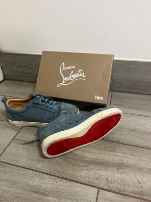 Marinblå Louboutins - Säljer nu dessa snygga marinblåa sneakers i mocka från Christian Louboutin. Köpte de för 3200:- på Plick i våras och har nu växt ut de och har inte hunnit använt de så mycke sen dess. Skokartong, Christian Louboutin påse, Christian Louboutin kort och kvitto medföljer.