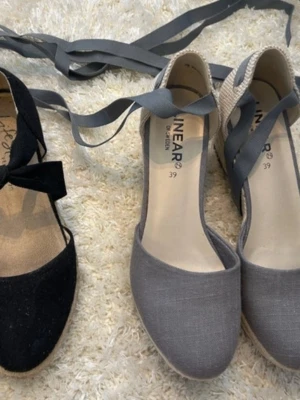2 klacksandaler - Två stycjna jätte fina sandaler med klack som är perfekt inför sommaren! Dom gråa är helt nya med prislappen kvar och de svarta är använda men i bra skick! Dom är i storlek 38/39 