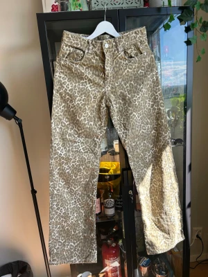 Beige leopardmönstrade jeans - Snygga jeans från Zara med beige leopardmönster och raka ben. Klassisk femficksmodell med knapp- och dragkedjegylf. Perfekta för dig som vill sticka ut med ett djurmönstrat plagg i garderoben.