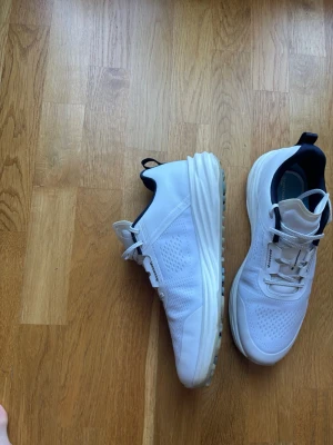 Vita sneakers med svarta detaljer - Ett par puma shadowcat NITRO 2.0.  Köptes 20/7-26 och säljs efter en runda då de var lite för stora för mig nypris 2000