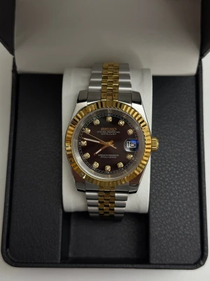 Seiko Mod, Two Tone Black Diamond - Seiko Black Diamond Mod. En väldigt unik seiko mod redo för att postas omgående. Bör ses I person.   - Urtavla och länk (rostfritt stål)  - Rörelse: Automatic NH35  - Box + resväska tillkommer vid köp  - Verktyg för att justera länk