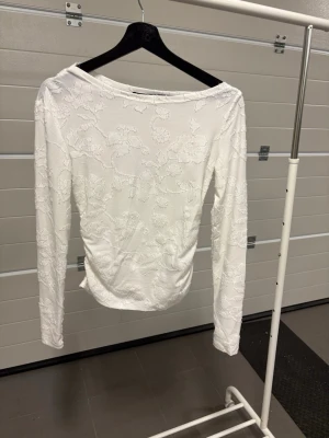  spetsblus vit genomskinlig  - Säljer en vit långärmad blus med vackert blommigt spetsmönster. Blusen är lite genomskinlig 