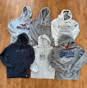 Mix av hoodies från kända märken superdry hollister les duex ralph lauren bvaldi  - Säljer ett paket med sex hoodies i olika grå och mörkblå nyanser från märken som Hollister, Superdry, Polo Ralph Lauren, Les Deux och Ewald. Alla har huva och tryck på bröstet, vissa med dragsko. Perfekt för dig som gillar streetwear och bekväma plagg. Strl:S✅ Pris kan diskuteras!💸 Hör av dig om du har funderingar!🤩