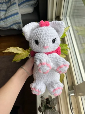 Virkad vit och rosa katt - Supersöt virkad katt av mitt eget mönster ”lady the Kitty” inspirerat av Disneyfilmen Aristocats! Har en supersöt rosett runt halsen och på huvudet. Denna katten är vit med rosa rosetter🤍💕🎀 !OBS, innehåller säkerhetsögon som ej rekommenderas för barn under 3 år! 