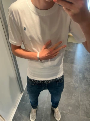Ralph Lauren t shirt  - Säljer en stilren vit t-shirt med korta ärmar och en liten broderad logga på bröstet. T-shirten har en klassisk passform och är gjord i mjuk bomull, perfekt till jeans eller shorts
