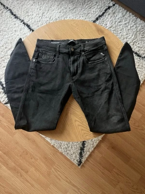 Svarta Replay Anbass - Hej👋 Säljer ett par svarta Replay jeans med fem fickor och silverfärgade nitar🤩 Jeansen har klassisk knappgylf och bälteshällor, har storleken W32 L32 i Anbass modell🧼 Materialet är troligtvis bomull med stretch för extra komfort😮‍💨Passar perfekt till en avslappnad och trendig stil😎 Meddela vid frågor!📩