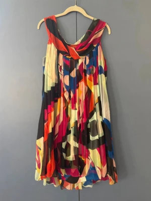 Färgglad silkig klänning Diane von Furstenberg - Säljer en färgstark och mönstrad kortklänning från Diane von Furstenberg i 100% silke. Klänningen har ett abstrakt mönster i rosa, rött, blått, svart, orange och beige samt en lös passform och draperad halsringning. Perfekt för dig som vill sticka ut! Vacker klänning i siden. Använd fåtal gånger.  Längd från axel är 100 cm.  Personen som buret den är stl 38.