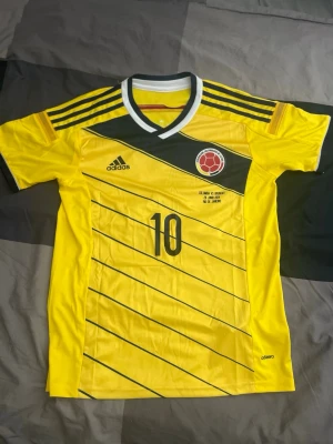 Colombia vm 2014 matchtröja - Äkta Colombia tröja ifrån vm 2014 med James Rodriguez på ryggen. Har även match print med Colombia-Uruguay från vm 2014 som Colombia vann och James Rodriguez gjorde två mål.
