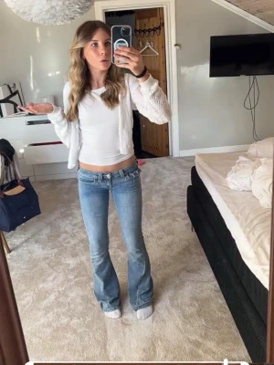 Ljusblå bootcut jeans med låg midja - Säljer ett par ljusblå bootcut jeans med låg midja och klassisk femficksmodell. Jeansen har en snygg tvättad look och är tillverkade i ett stretchigt denimtyg som sitter bekvämt. Perfekta för dig som gillar retrovibbar och vill ha ett par jeans som sticker ut.LITE UPPSYDA 70 cm HELT NYA ANVÄNT 1-2 gång 🫶🏻storlek 23w