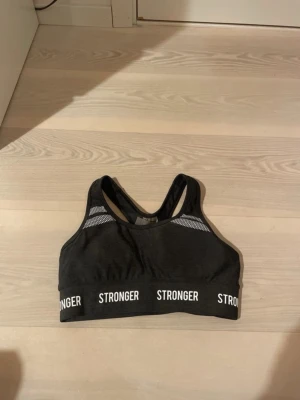 Svart sport-bh från Stronger - Snygg svart sport-bh från Stronger!! Aldrig använd!!