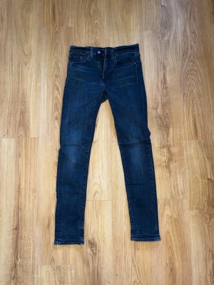 Mörkblå slim fit jeans från Levi's - Snygga mörkblå skinny jeans från Levi's med klassisk femficksmodell och smal passform. Jeansen har en diskret tvätt och är tillverkade i stretchigt denim för extra komfort. Perfekta till en avslappnad streetstyle-look. 31/34