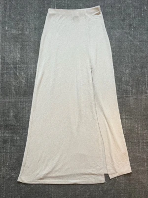 Beige långkjol med slits - Jag säljer en beige långkjol med slits från Gina Tricot i storlek XS. Den har ett litet mörkare märke på baksidan, (se bild 3). Skriv vid funderingar!💗🌸