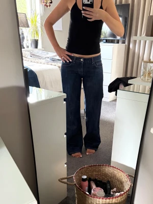 mörkblå jeans från Zara  - Säljer ett par mörkblå jeans med rak passform och låg midja från Zara. Jeansen har klassisk femficksdesign och stängs med knapp och dragkedja. Perfekta till en avslappnad look och passar till det mesta. Materialet är denim i bomull.