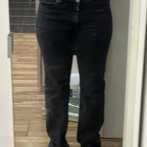 Svarta raka jeans - Svarta jeans med rak passform och klassisk femficksdesign. Byxorna har normal midja och är tillverkade i ett mjukt denimtyg som ger en bekväm känsla. Perfekta för dig som gillar en enkel och stilren look.