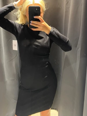 Filippa K Svart långärmad klänning - En stilren svart klänning med lång ärm och kroppsnära passform från Filippa K ❤️ 