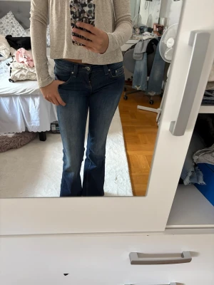Mörkblå bootcut jeans - Säljer ett par mörkblå bootcut jeans med klassisk femficksmodell och låg midja. Säljer då dom tyvärr blivit för små
