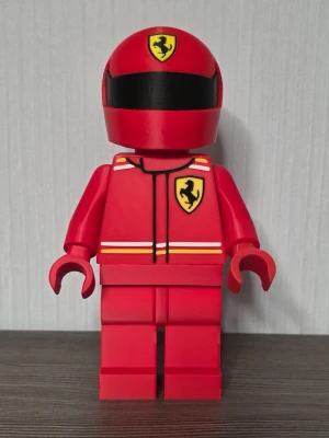 Stor röd LEGO Ferrari-figur - Säljer en stor LEGO-inspirerad figur i rött med Ferrari-logga på hjälmen och bröstet. Figuren har racingdräkt med gula och vita detaljer samt svart visir på hjälmen. Perfekt som dekoration för bil- eller LEGO-fans.