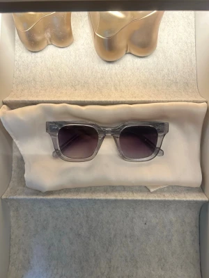 Grå transparenta fyrkantiga solglasögon - Snygga solglasögon med transparent grå båge och fyrkantig form. Glasen är mörktonade och ger en cool look. Perfekta för soliga dagar när du vill sticka ut lite extra.
