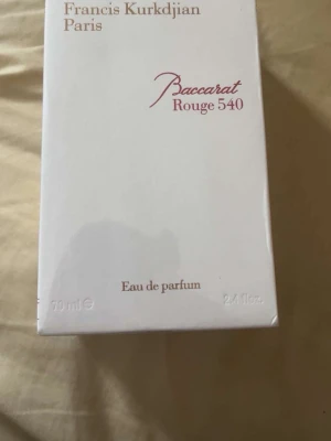 Baccarat Rouge 540 Eau de Parfum 70ml - Maison Francis Kurkdjian Baccarat Rouge 540 Eau de Parfum i elegant vit kartong med röda och guldiga detaljer. Flaskan innehåller 70 ml och doften är känd för sin lyxiga och unika karaktär. Perfekt för dig som vill ha en exklusiv parfym.