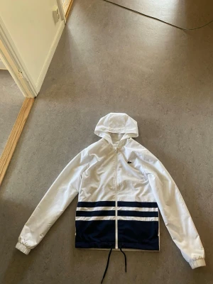 Vit och marinblå vindjacka Lacoste - Jätte najs Lacoste windbreaker storlek XS passar S den är i hyfsat bra skicka 