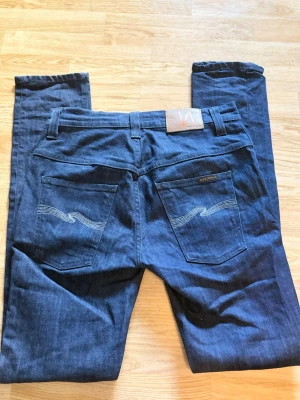 Mörkblå nudie jeans  - Hej, säljer nu mina mörkblå nudie jeans. Dem är i gott skick utan defekter, skick 9/10. Storlek syns på sista bilden!  Nypris ungefär ~1600, mitt pris 400. Hör av er vid frågor eller funderingar!