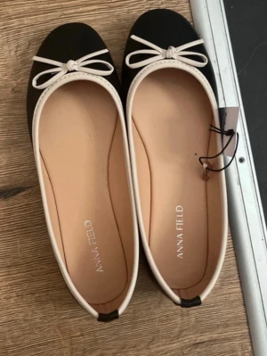 Svarta ballerinaskor med rosett - Helt nya ballerina skor från Anna field i storlek 38, säljer då de inte passar mig🥰 fotlängd är 24-24,3