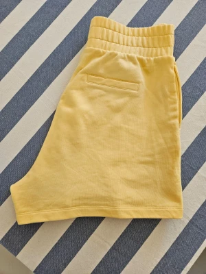 Shorts Residus, Stl M - ☀️ Superfina gula shorts från svenska Residus, känt för sitt fokus på hållbart mode och högkvalitativa basplagg ☀️  Tillverkade i 100% organisk bomull vilket ger ett mjukt och behagligt sweatshirttyg. Dekorfickor. Köpta på Vinted.
