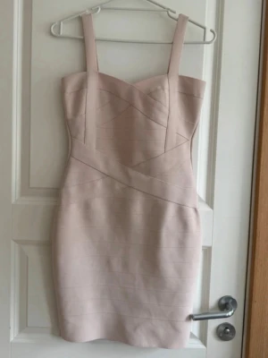 Ljusrosa/beige bandageklänning - Snygg ljusrosa bandageklänning med breda axelband och figurnära passform. Storlek S! Har några små fläckar (se bilder) absolut inget man tänker mycket på. Dom går säkert att få bort har inte testat. Annars fint skick. Köp direkt för 199kr via köp nu💞