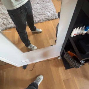 Svarta jeans från Replay - Snygga svarta jeans från Replay med en klassisk femficksdesign. Jeansen har en diskret tvättad look och är perfekta för en stilren vardagsoutfit. De har en knappgylf och bälteshällor för extra stil och funktion. Liten defekt där bak på jeansen som inte syns vid användning.
