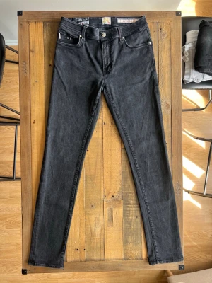 Tramarossa jeans - Snygga svarta jeans i klassisk femficksdesign. Jeansen har silverfärgade nitar och knapp, samt bälteshällor. Materialet är denim med en mjuk känsla och lätt stretch för extra komfort.