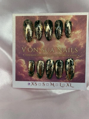 Aurelia (XS);Medium Almond - Handgjorda press-on nails i Medium Almond med mörkgrön bas, guldfolie och guldfärgade metalldetaljer. Den oregelbundna guldeffekten gör varje nagel unik och ger setet en mörk, lyxig finish.  Storlek: XS Form: Medium Almond 10 handgjorda naglar Prep-kit medföljer med alla set.