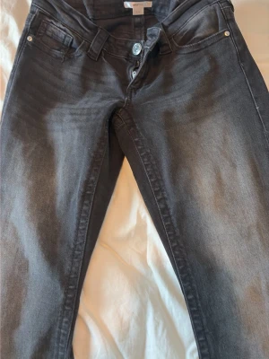 Grå lågmidjade jeans med broderade fickor - Snygga grå lågmidjade  jeans med klassisk femficksmodell och broderade detaljer på bakfickorna. Jeansen har knappgylf och bälteshällor. Dessa jeans är sydda då de var för stora för mig så de sitter som S🩷 