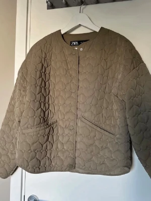 Quiltad beige cardiganjacka från Zara - Quiltad beige cardiganjacka från Zara med hjärtformat mönster. Säljer då jag behöver pengarna🥰