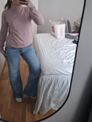 Ljusrosa polotröja stickad - Säljer en ljusrosa /smutsrosa stickad polotröja med långa ärmar och ribbade detaljer vid hals, ärmslut och nederkant. Tröjan har en mjuk och tunn stickning som passar perfekt till jeans eller kjol. Enkel och stilren design som är lätt att matcha.